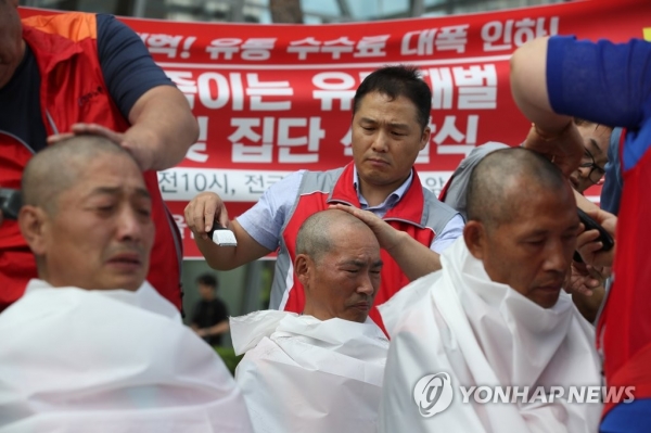 ▲제화노동자들이 지난 7월 서울 영등포구 전경련회관 앞에서 백화점 유통 수수료 인하를 요구하며 집단 삭발을 하고 있다.