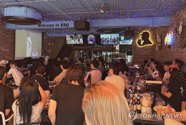 2일 서울 BBQ홍대입구점을 찾은 시민들이 치킨을 먹으며 2026 북중미 월드컵 조별리그 A조 한국과 체코의 경기를 관람하고 있다. 2026.6.12 [제너시스BBQ그룹 제공]<br>